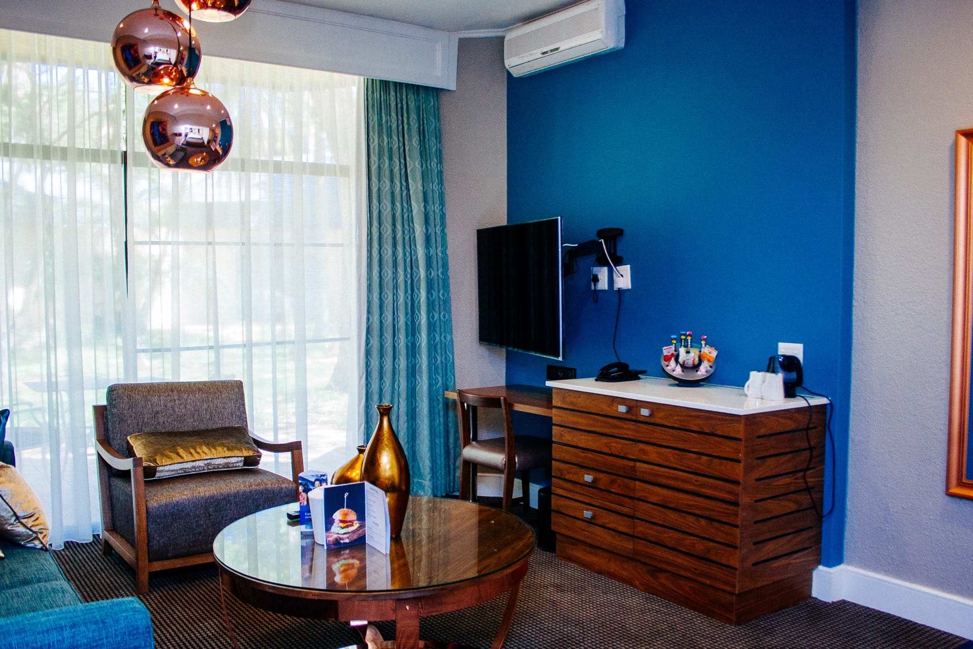 Executive Villa lounge with writing desk and armchair at Walmont at Mmabatho Palms, Mahikeng