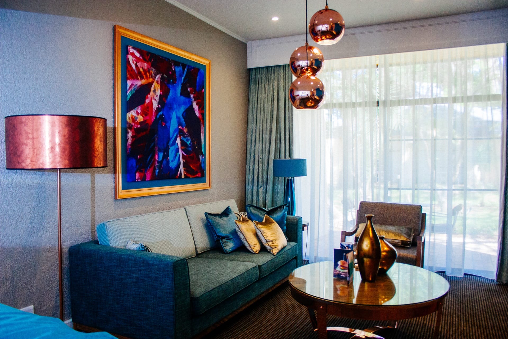 Executive Villa lounge with teal sofa and copper pendants at Walmont at Mmabatho Palms, Mahikeng